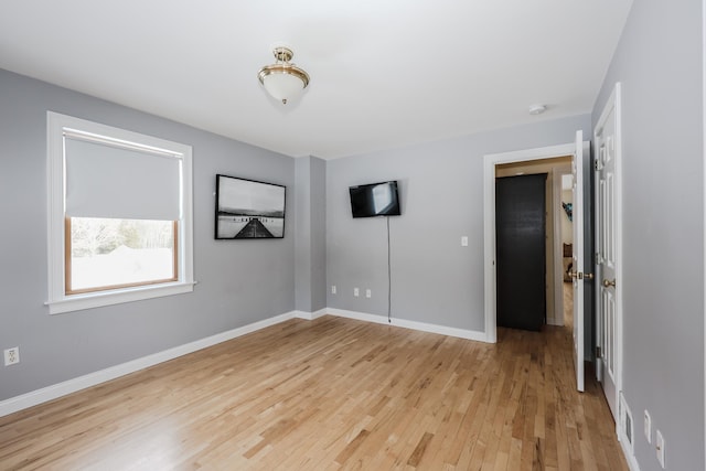 unfurnished bedroom featuring light wood-style flooring and baseboards