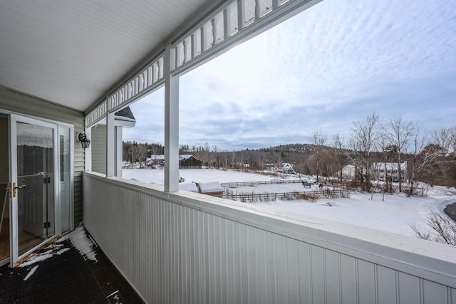 view of snow covered back of property