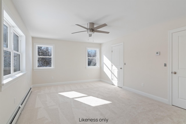 spare room featuring a baseboard heating unit, baseboards, a ceiling fan, and light colored carpet