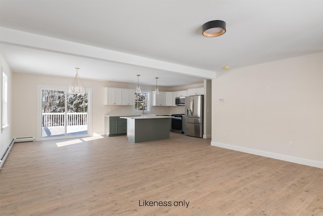 kitchen featuring a kitchen island, open floor plan, light countertops, appliances with stainless steel finishes, and pendant lighting