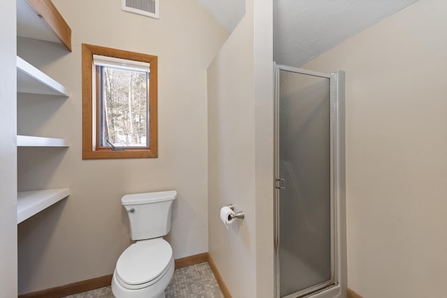 bathroom with visible vents, a shower stall, toilet, and baseboards