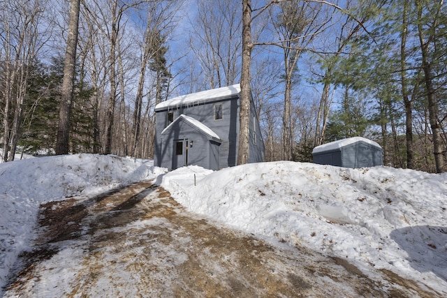 view of snow covered exterior with a garage and a storage unit