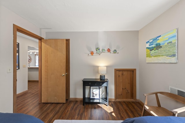 bedroom featuring dark wood-style flooring and baseboards