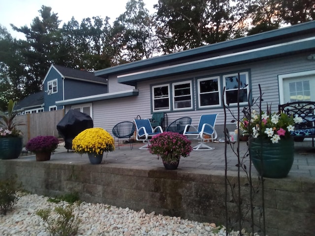 rear view of property featuring a patio and fence