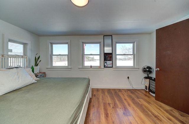 bedroom with baseboards and wood finished floors