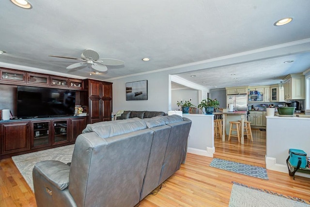 living room featuring light wood-style floors, recessed lighting, ornamental molding, and a ceiling fan