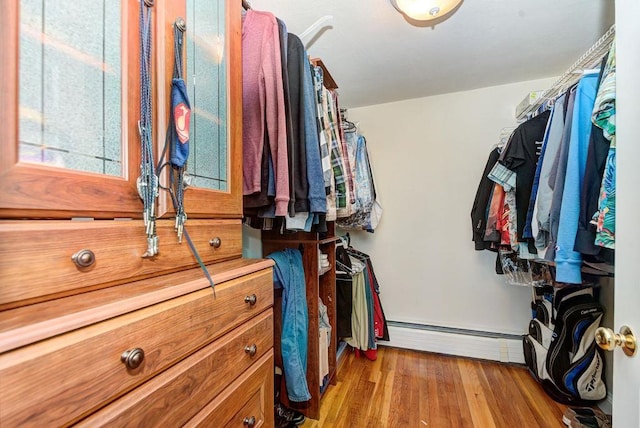 spacious closet with a baseboard radiator and wood finished floors