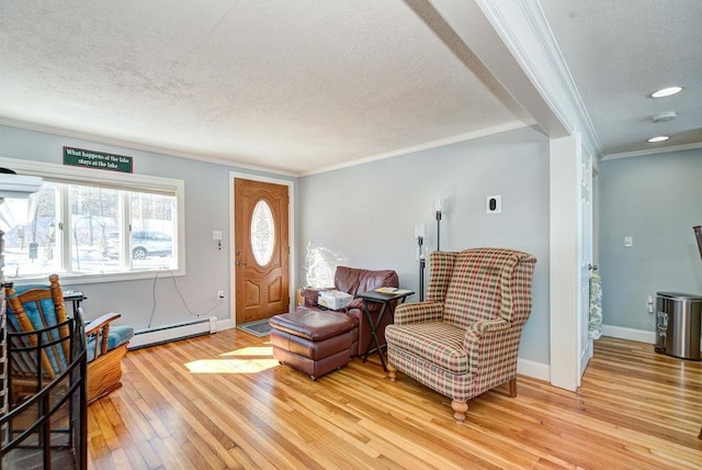 interior space with crown molding, light wood finished floors, a baseboard heating unit, a textured ceiling, and baseboards