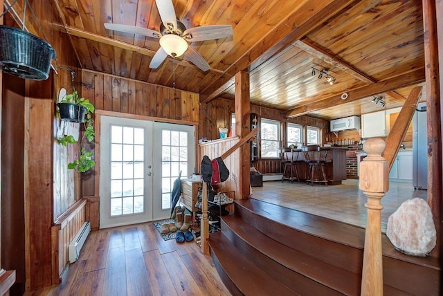 interior space featuring wood ceiling, stairway, baseboard heating, and wood finished floors