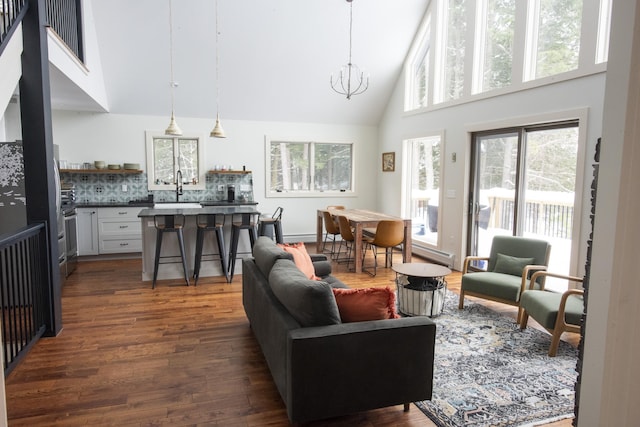 living area featuring a chandelier, dark wood finished floors, and high vaulted ceiling