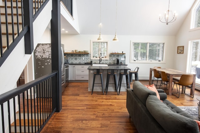 kitchen with a breakfast bar, dark countertops, white cabinetry, and hanging light fixtures