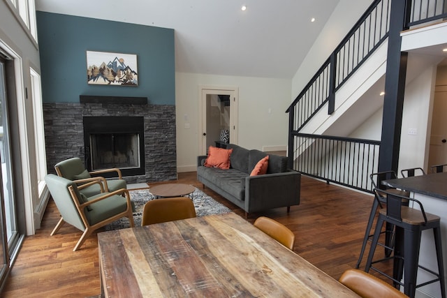 living area with stairs, a fireplace, wood finished floors, and baseboards