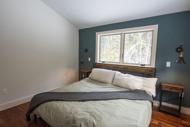 bedroom featuring lofted ceiling, dark wood-type flooring, and baseboards