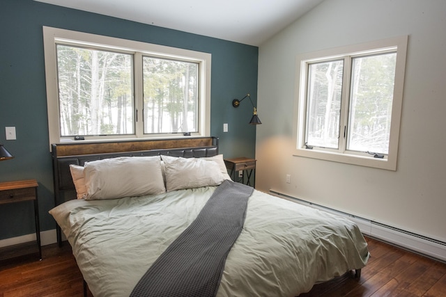 bedroom with vaulted ceiling, dark wood finished floors, and baseboard heating