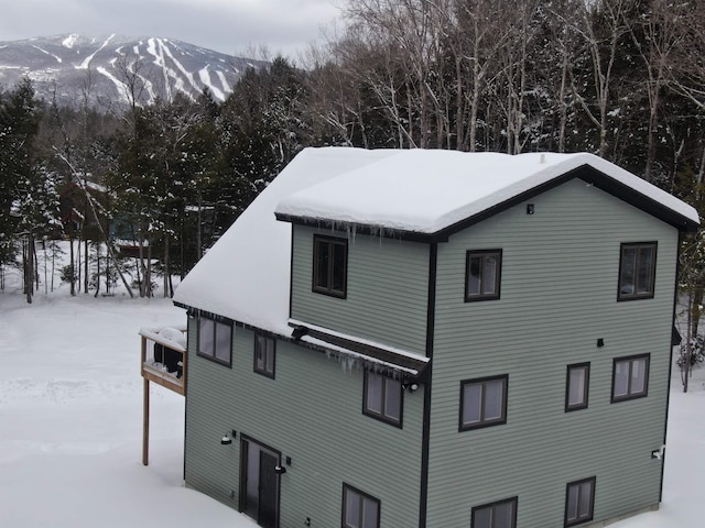 view of snowy exterior with a deck with mountain view