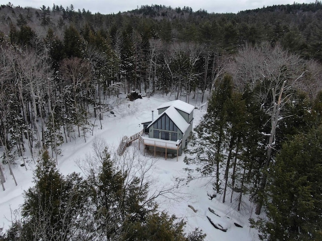 snowy aerial view featuring a forest view