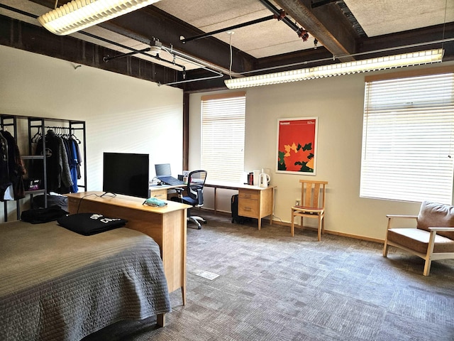 bedroom with carpet floors, beam ceiling, and baseboards