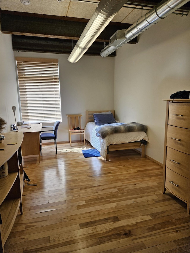 bedroom featuring light wood finished floors, visible vents, and baseboards