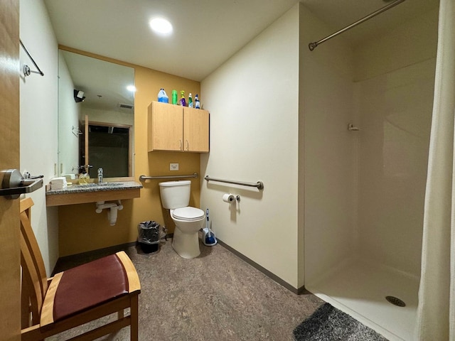 full bathroom featuring toilet, a shower stall, baseboards, and a sink