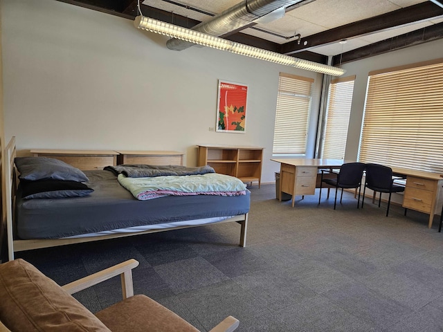 bedroom with carpet, beam ceiling, and track lighting