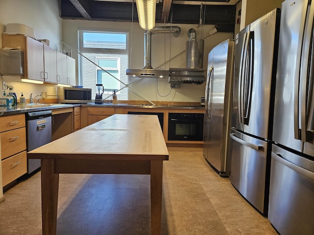 kitchen with light floors, appliances with stainless steel finishes, and wall chimney range hood