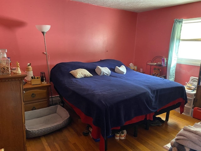 bedroom with light wood-style floors and a textured ceiling