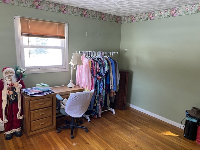 office space with a textured ceiling, baseboards, and wood finished floors