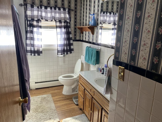 bathroom featuring a wainscoted wall, baseboard heating, tile walls, and wallpapered walls