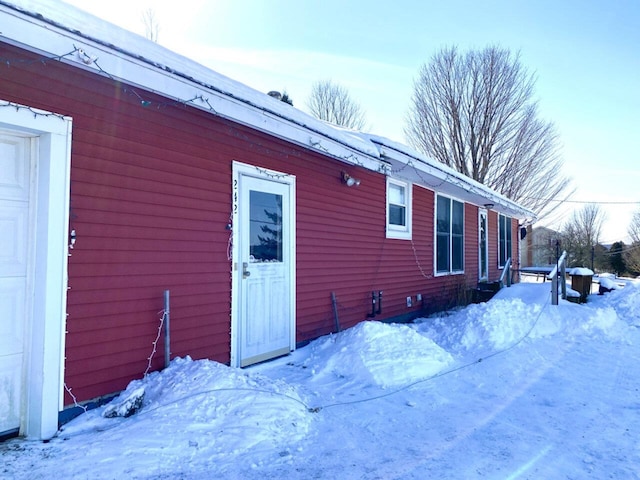 view of snow covered exterior featuring a garage