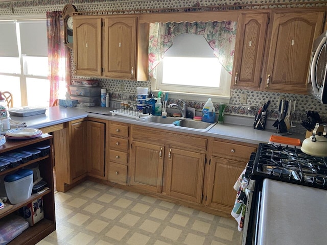 kitchen featuring light countertops, appliances with stainless steel finishes, light floors, and a sink