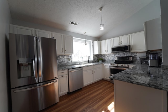 kitchen with a sink, visible vents, white cabinetry, appliances with stainless steel finishes, and decorative light fixtures