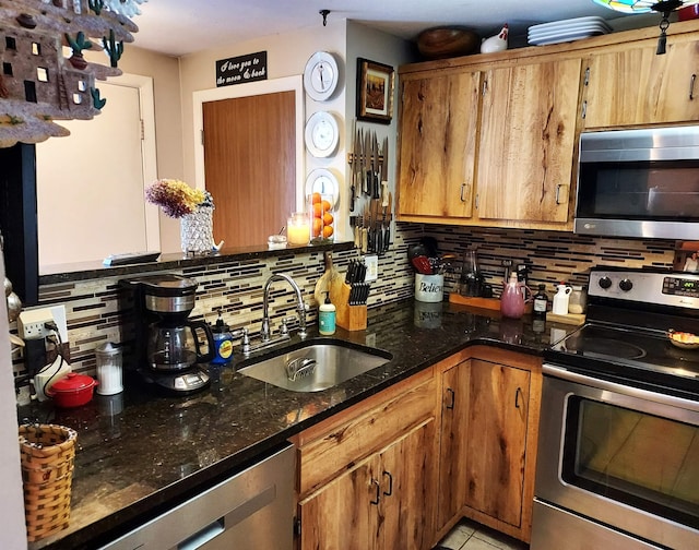 kitchen featuring appliances with stainless steel finishes, brown cabinetry, a sink, and backsplash