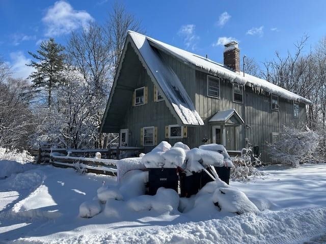 snow covered property featuring a chimney