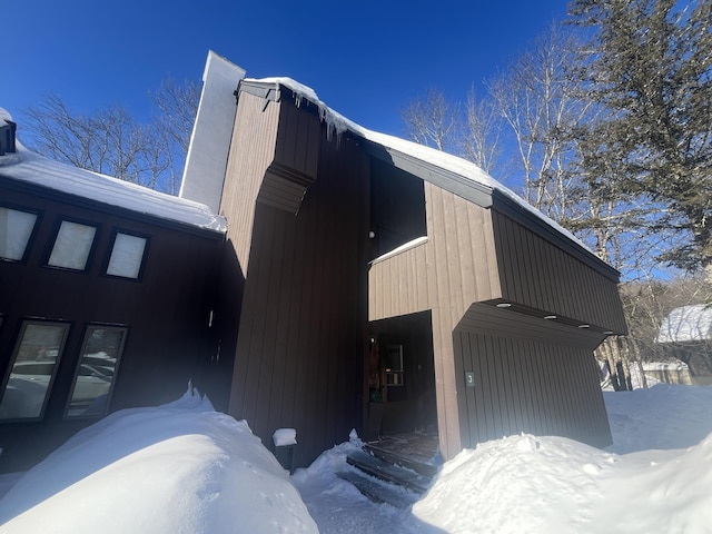 snow covered property with a garage