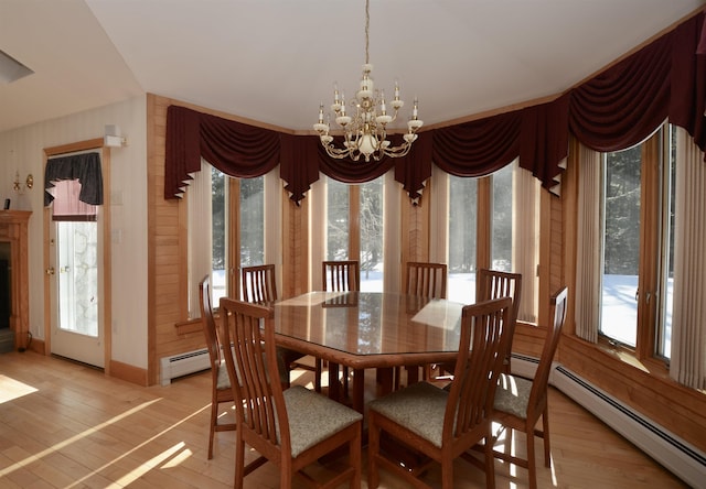 dining space featuring a chandelier, a baseboard radiator, and light wood finished floors