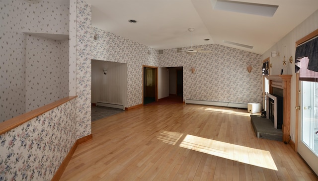 living room with a baseboard radiator, a fireplace with raised hearth, baseboard heating, vaulted ceiling, and wallpapered walls