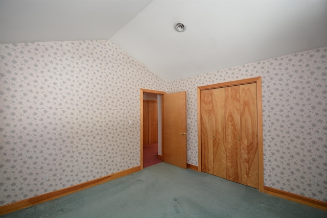 unfurnished bedroom featuring carpet, vaulted ceiling, and wallpapered walls