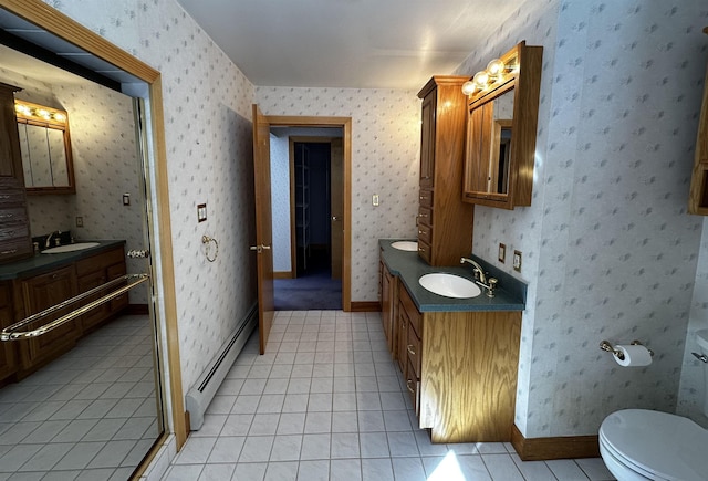 bathroom featuring a baseboard heating unit, tile patterned flooring, a sink, and wallpapered walls