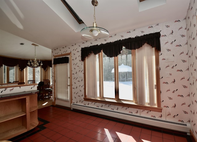 interior space featuring hanging light fixtures, baseboard heating, an inviting chandelier, dark tile patterned floors, and wallpapered walls