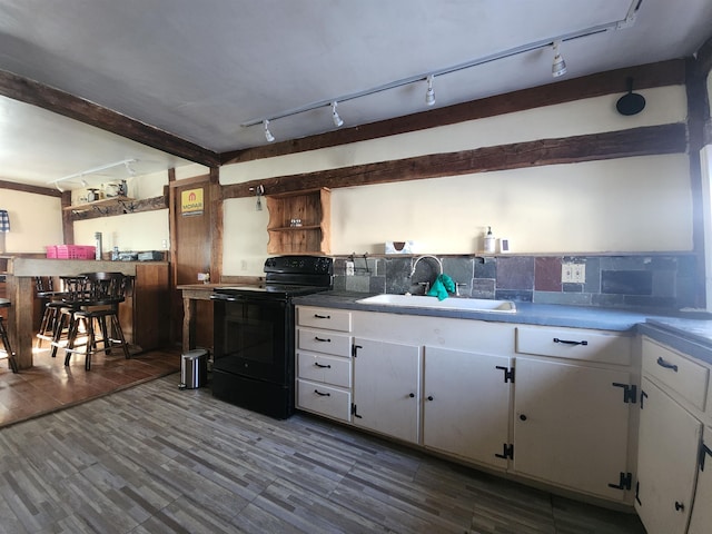 kitchen with black / electric stove, track lighting, white cabinetry, and a sink