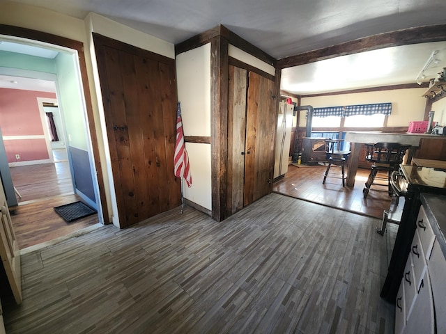 interior space with beamed ceiling, range with electric cooktop, and wood finished floors