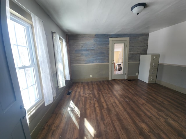 interior space with baseboards, visible vents, and dark wood-style flooring