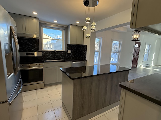 kitchen featuring gray cabinetry, stainless steel appliances, a sink, a center island, and pendant lighting