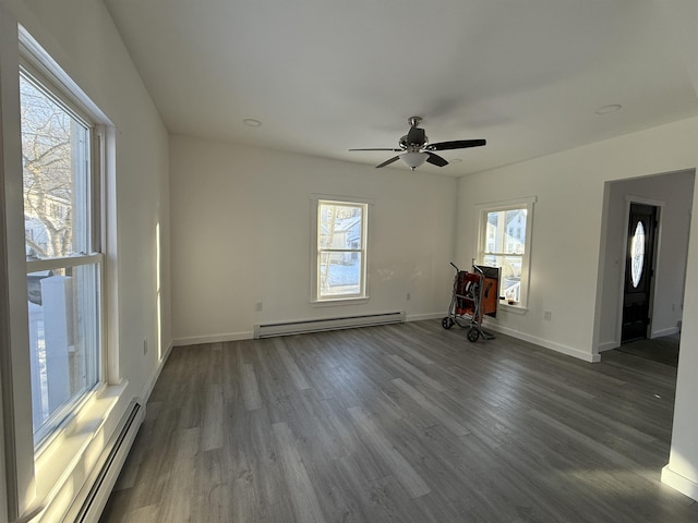 unfurnished room featuring a baseboard heating unit, dark wood-style flooring, a ceiling fan, and baseboards