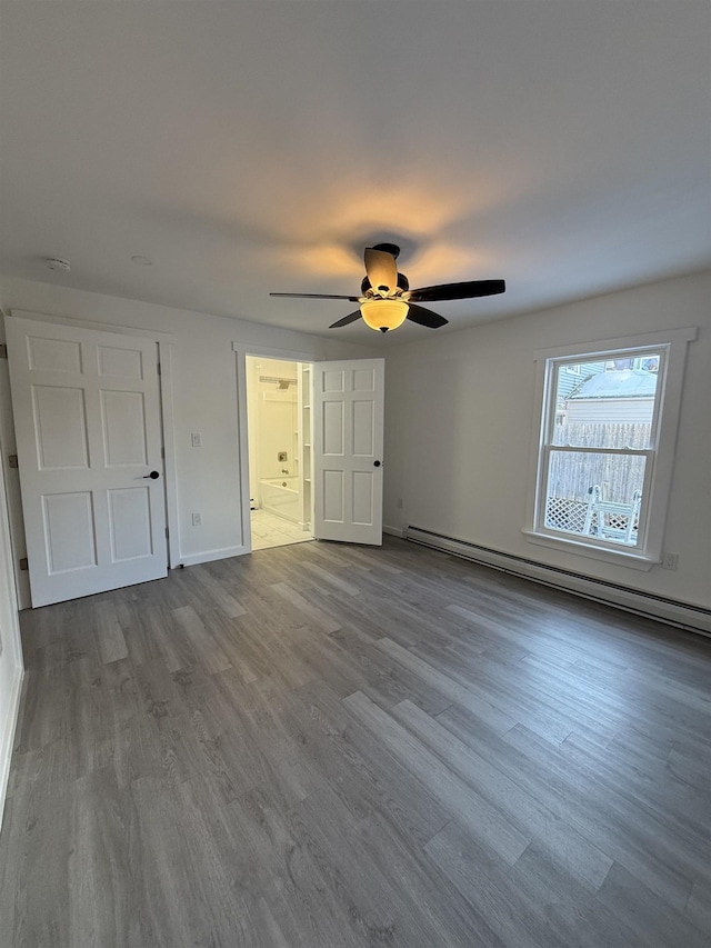 unfurnished bedroom featuring light wood finished floors, baseboards, ensuite bath, ceiling fan, and a baseboard heating unit