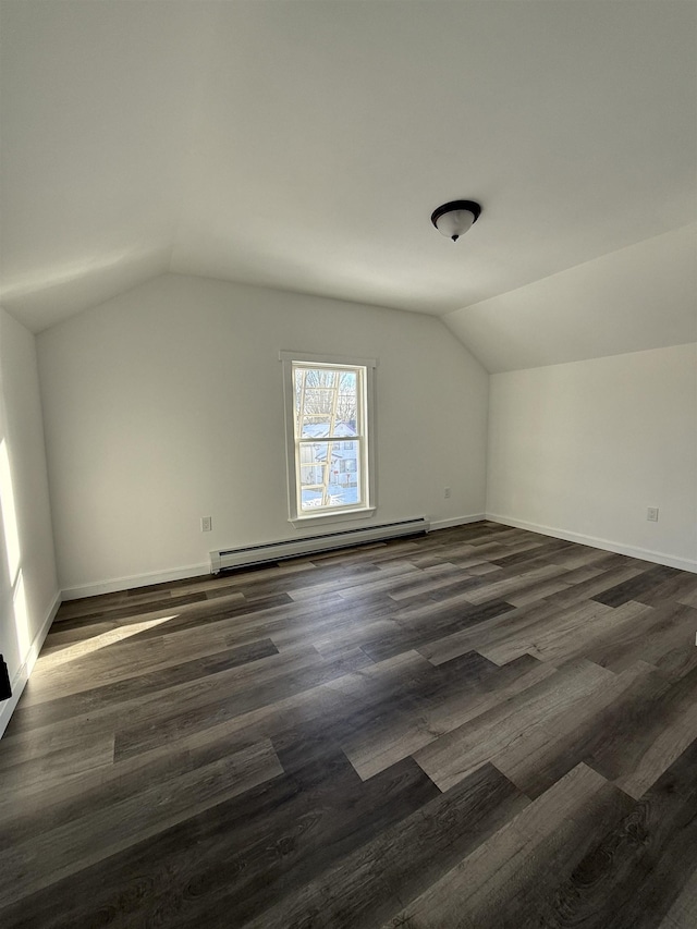 additional living space with lofted ceiling, baseboards, a baseboard heating unit, and dark wood-type flooring