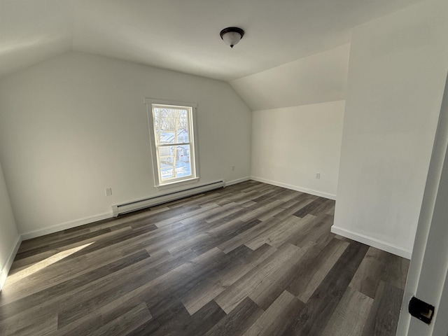 additional living space featuring a baseboard heating unit, dark wood-type flooring, vaulted ceiling, and baseboards