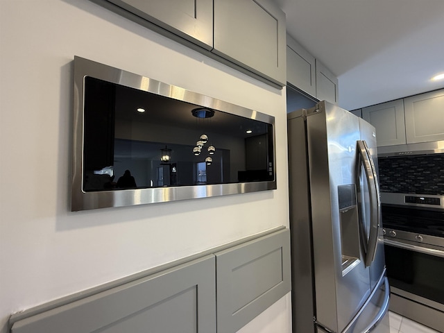 kitchen featuring gray cabinets, appliances with stainless steel finishes, light countertops, and decorative backsplash