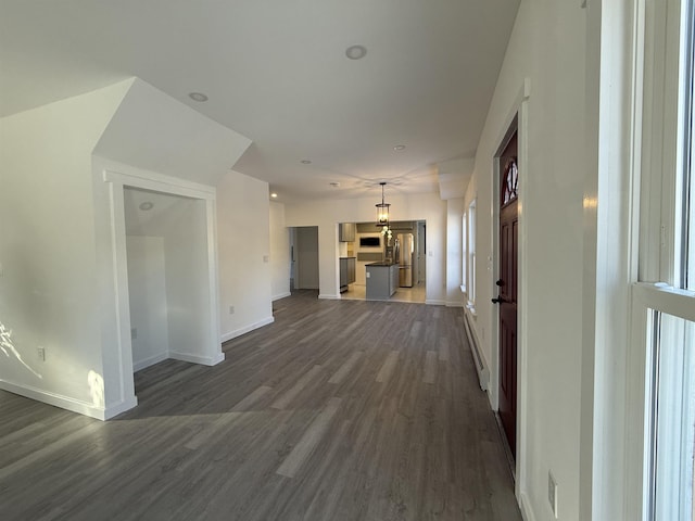 unfurnished living room featuring dark wood-style floors and baseboards