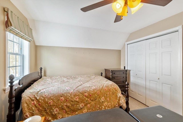 bedroom featuring vaulted ceiling, ceiling fan, a closet, and light colored carpet